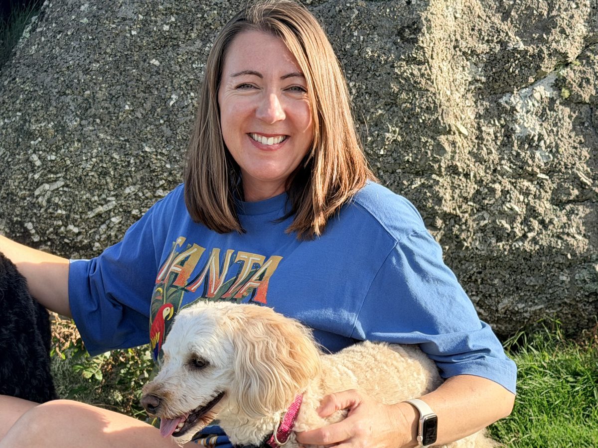 Sarah Rees of Guiding Therapy, smiling, with her dog